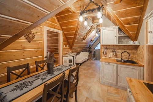 a kitchen with wooden walls and a ceiling with beams at TatrApart in Zakopane