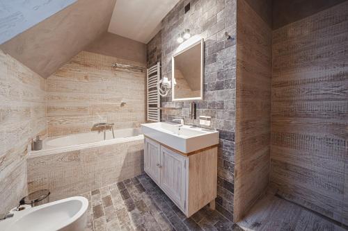 a bathroom with a sink and a tub and a toilet at TatrApart in Zakopane