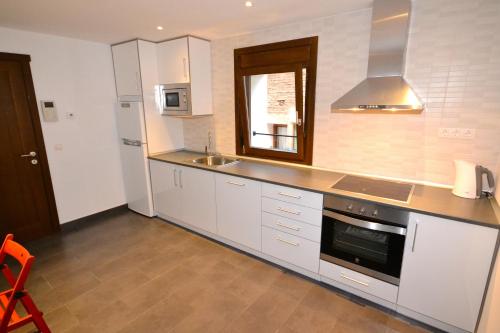 a kitchen with white cabinets and a stove top oven at La Casa de las Aldeas in Daroca