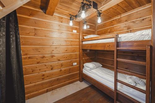 a bedroom with two bunk beds in a log cabin at TatrApart in Zakopane