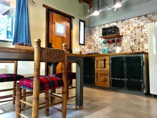 eine Küche mit einem Holztisch und einigen Stühlen in der Unterkunft Toca Madera in Merlo