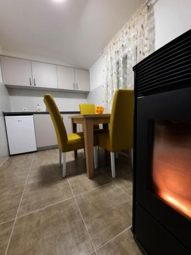 a kitchen with a dining table and yellow chairs at DION Kolašin in Kolašin