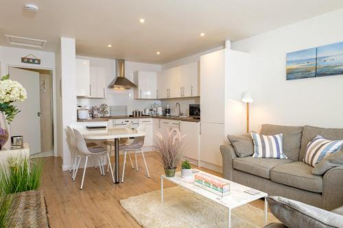 a living room with a couch and a table at West Bay Cottages Yarmouth Isle of Wight in Yarmouth