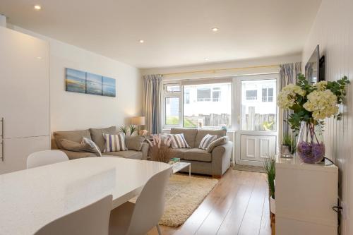 a living room with a couch and a table at West Bay Cottages Yarmouth Isle of Wight in Yarmouth