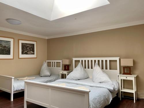 a bedroom with two white beds and two tables at Apartmán Galerie in Děčín