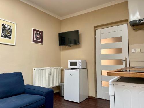 a living room with a blue couch and a microwave at Apartmán Galerie in Děčín