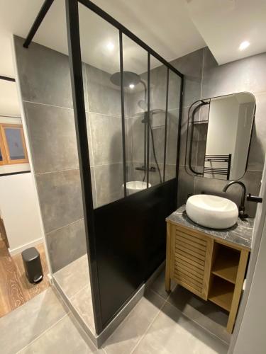 a bathroom with a shower with a sink and a mirror at Appartement neuf Méribel hyper centre accès pistes in Méribel