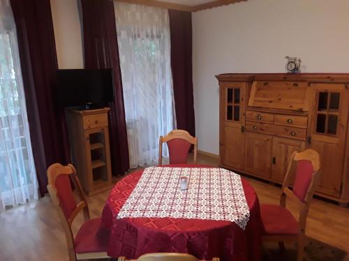 a dining room with a table and a dresser at Pension Waldeck Fleckl in Warmensteinach