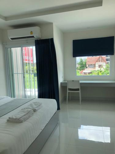 a bedroom with a bed and a large window at Icare Residence & Hotel in Bangkok