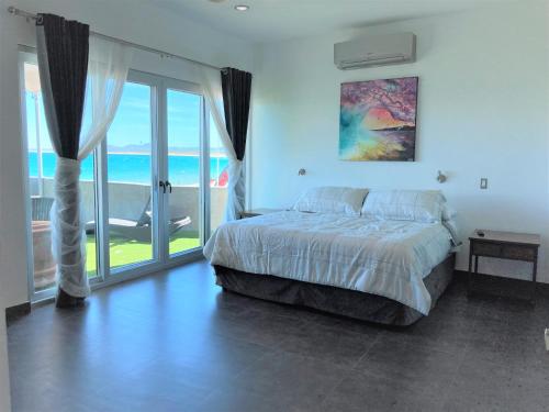 a bedroom with a bed and a view of the ocean at Baja Joe's Hotel in La Ventana