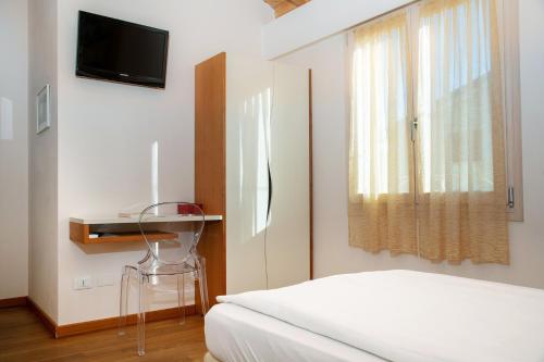 1 dormitorio con 1 cama, TV y ventana en Via Verdi B&B, en Vago
