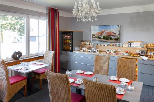a dining room with tables and chairs and a kitchen at Tiemanns Boardinghouse in Lemförde