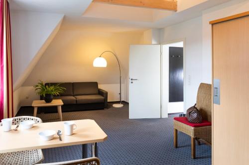 a living room with a couch and a table at Tiemanns Boardinghouse in Lemförde