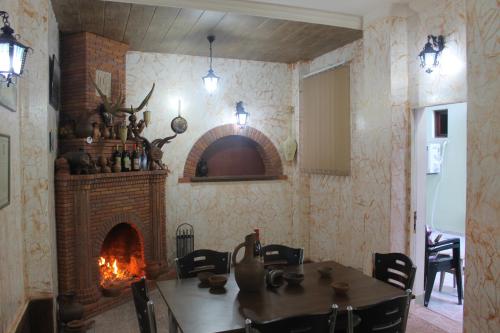 a dining room with a table and a fireplace at Marani Hotel in Batumi