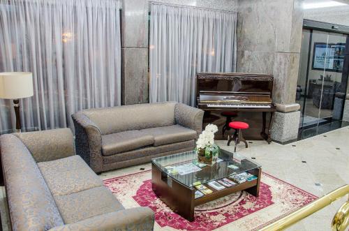 a living room with a couch and a piano at Bourbon Londrina Hotel in Londrina