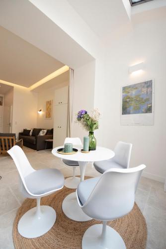 un salon avec une table et des chaises blanches dans l'établissement Mayenne, à Paris
