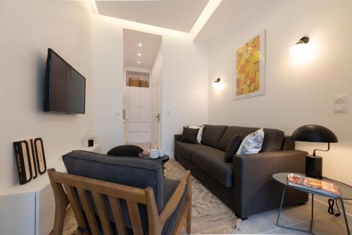 ein Wohnzimmer mit einem Sofa und einem TV in der Unterkunft Mayenne in Paris