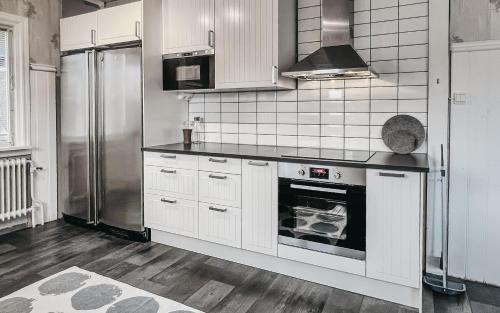 a kitchen with white cabinets and a stainless steel refrigerator at Säfsen House • Spacious updated home • Close to the slopes! in Fredriksberg