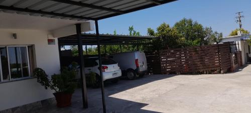 a white truck parked under a shed in a driveway at Apartamento Familiar Marta in Colonia del Sacramento