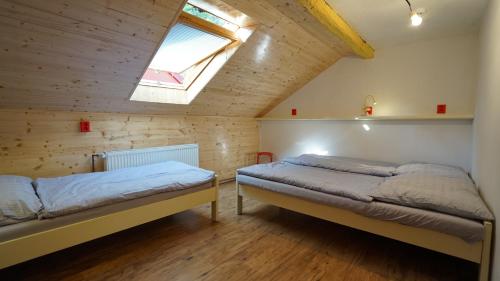 een slaapkamer met 2 bedden en een dakraam bij Chata pod hradem in Sloup