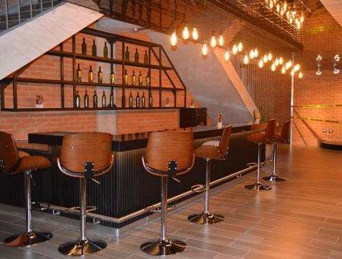a bar with brown bar stools in a room at Cozy Stays Cayala Apartments 4 in Guatemala