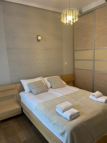 a bedroom with a large bed with towels on it at Cosy - Neptun Park by OneApartments in Gdańsk