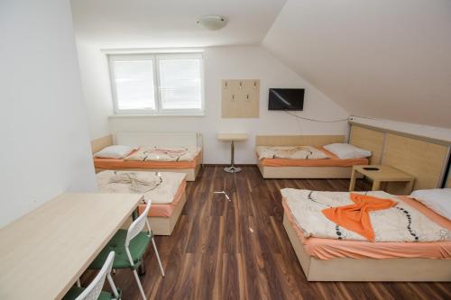 a dorm room with four beds and a table at Penzion Hviezda in Bratislava