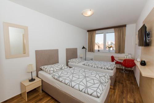 a hotel room with two beds and a window at Penzion Hviezda in Bratislava