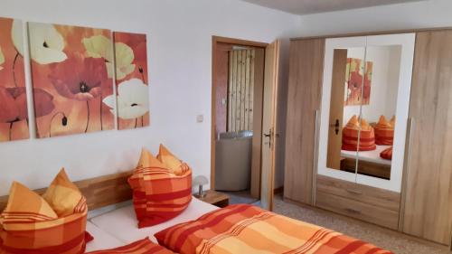 una camera con 2 letti con cuscini arancioni e arancioni di Ferienwohnung Am Stachelsrain a Zella-Mehlis