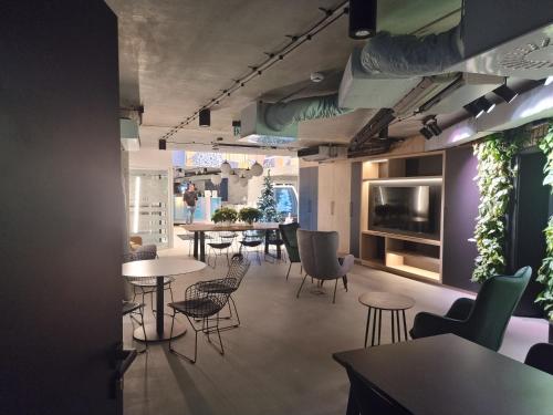 a dining room with tables and chairs and a tv at Apartament Złota Perła Czarna Góra in Sienna