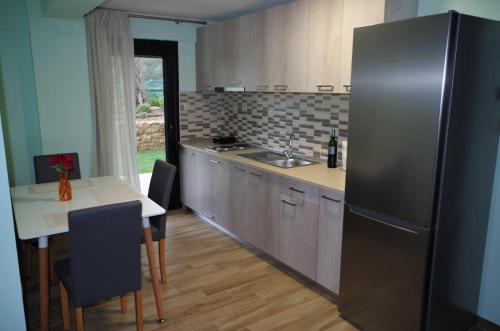 a kitchen with a stainless steel refrigerator and a table at Anesis Luxury Apartments in Skala Sotiros