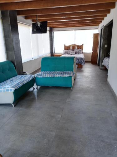 a room with two blue couches and a bed at Mazamitla Pinos del Rio in Mazamitla