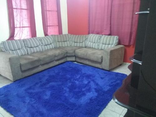 sala de estar con sofá y alfombra azul en Santo Ivo 3, en Aparecida