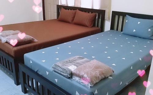 Dos camas en una habitación con corazones pintados. en รสริน ซีวิว en Pattaya North