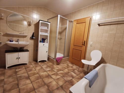 een badkamer met een bad, een wastafel en een douche bij Haus Bullachberg in Schwangau