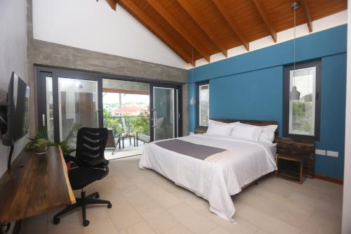 a bedroom with a bed and a desk and windows at Sol Sanctum - Boutique Wellness Hotel in Gros Islet