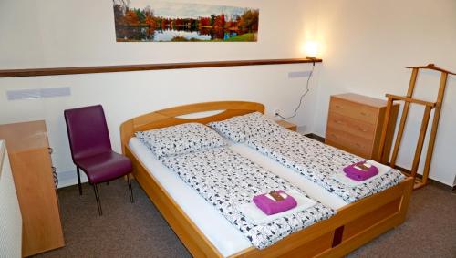 a bedroom with a bed and a purple chair at Vila Edith Valtice in Valtice