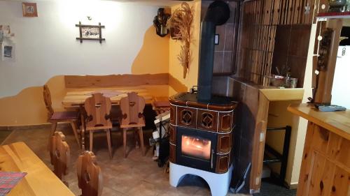 a kitchen with a stove and a table with chairs at Chata U Vlastíka in Malá Morávka