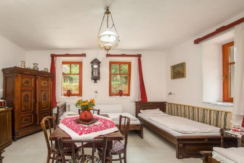 a room with two beds and a table and chairs at Kék-Túra Vendégház in Füzér