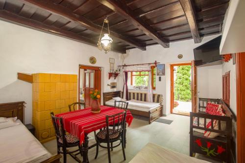a dining room with a table and chairs and a bedroom at Kék-Túra Vendégház in Füzér
