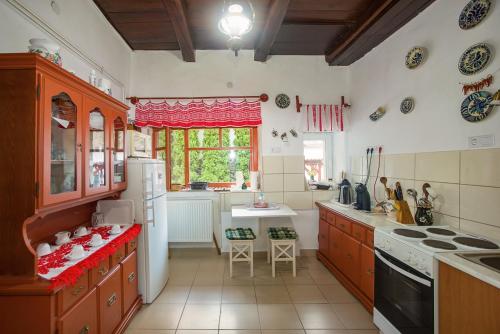 a kitchen with wooden cabinets and a stove top oven at Kék-Túra Vendégház in Füzér