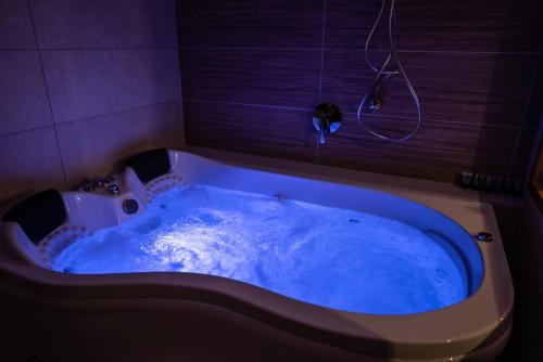 a bath tub filled with blue water in a bathroom at Sunset B&B in Ein Kinya