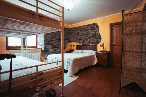 a bedroom with two bunk beds and a brick wall at Apartamentos Rurales Los Galpones in Coaña