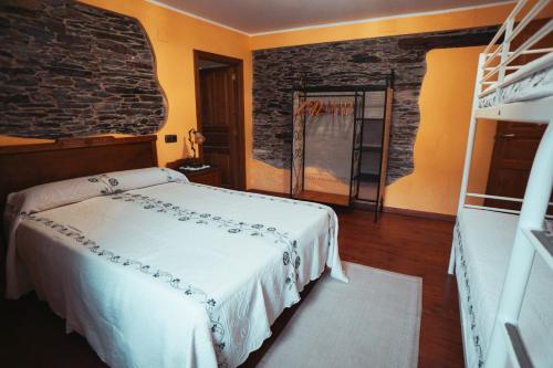 a bedroom with a bed and a brick wall at Apartamentos Rurales Los Galpones in Coaña