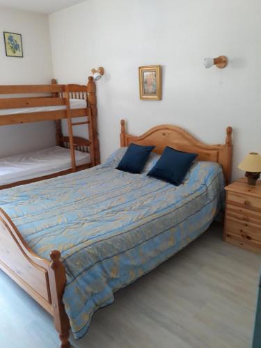 a bedroom with a wooden bed with blue pillows at T2 Résidence de l'Ars Aulus les Bains in Aulus-les-Bains