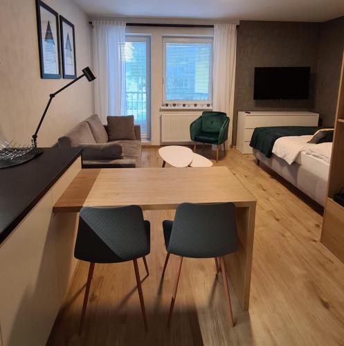 ein Wohnzimmer mit einem Bett, einem Tisch und Stühlen in der Unterkunft Apartmán Hestia 5 in Rajecké Teplice