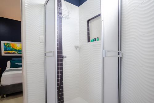 a shower with a glass door in a bathroom at Montepinares Apartaestudios in Montería