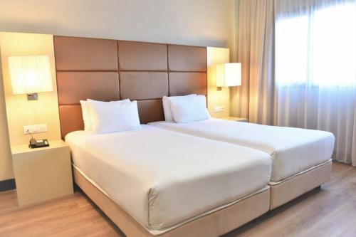 a large white bed in a hotel room at Holiday Inn Madrid - Las Tablas by IHG in Madrid