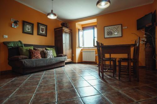 a living room with a couch and a piano at Apartamentos Rurales Los Galpones in Coaña