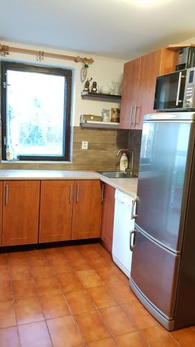 a kitchen with a stainless steel refrigerator and a window at Dům V Podzámčí in Mělník